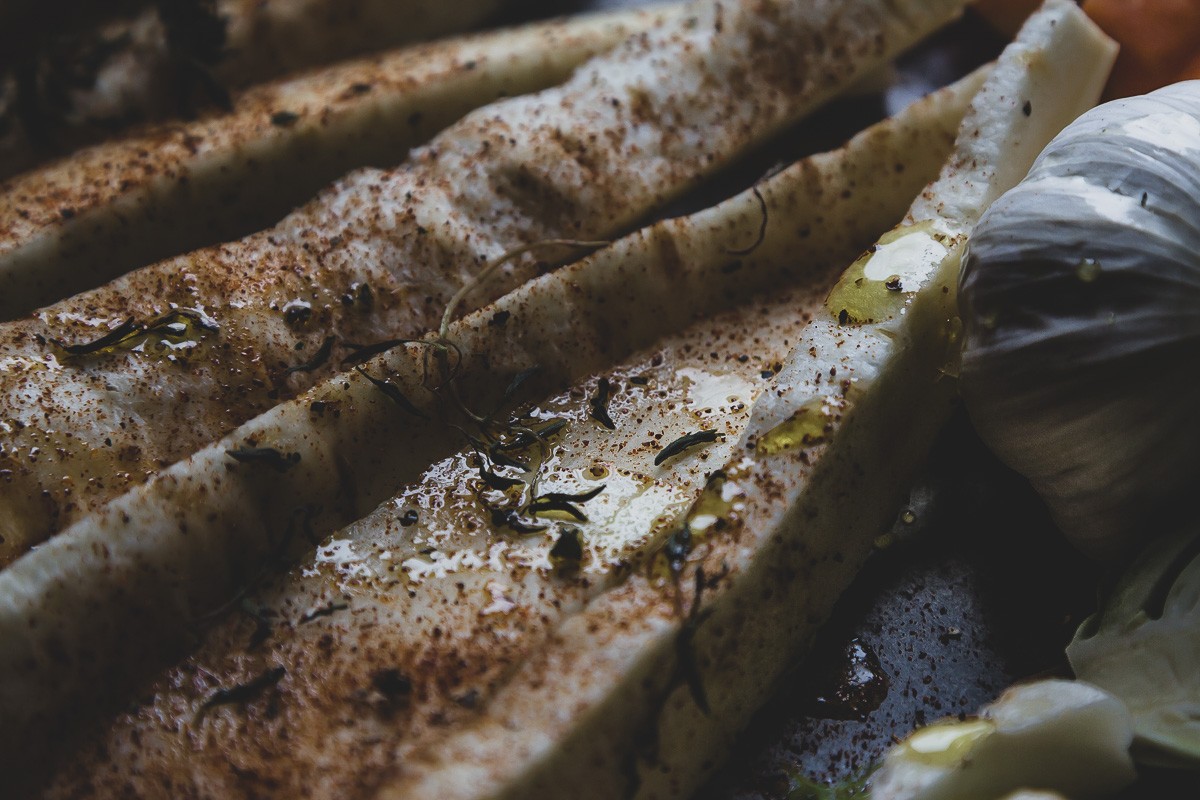 raw parsnips and garlic with herbs and olive oil in a sheet pan | sultryvegan.com