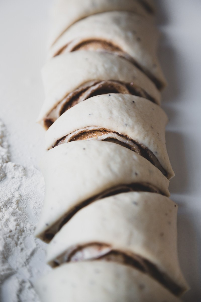 finnish cinnamon buns cut in a triangle shape on a white table with some flour on it