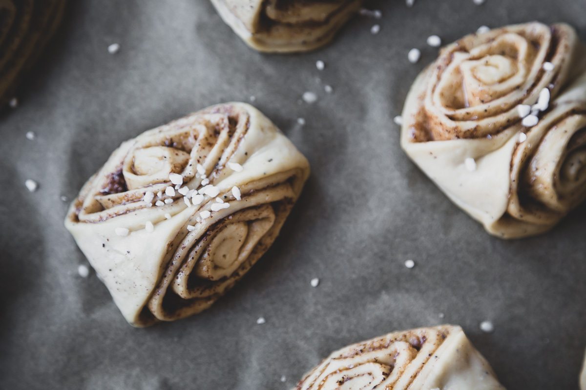 unbaked vegan finnish cinnamon buns on an unbleached parchment paper