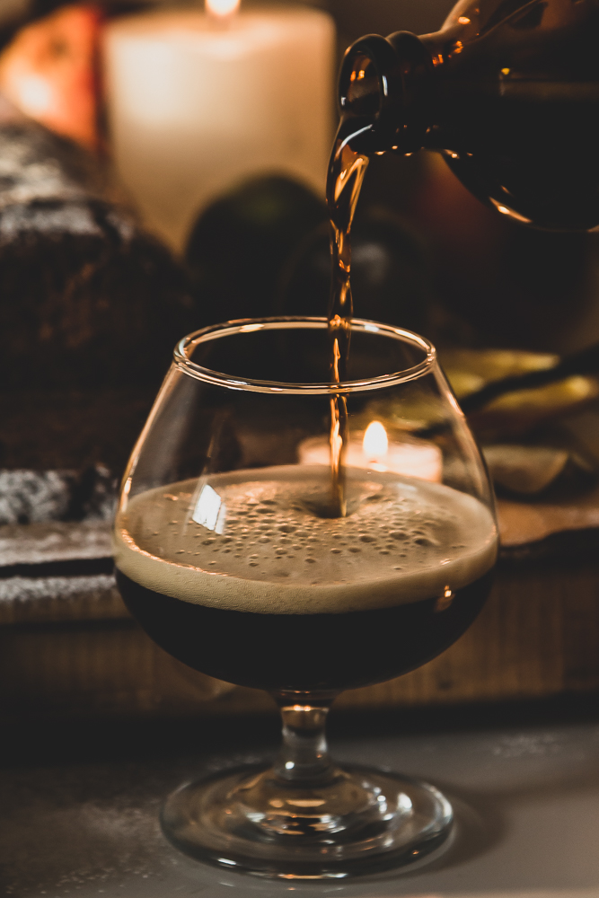 Dark beer is being poured into a glass