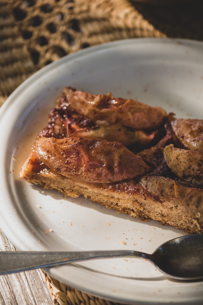 A slice of vegan cinnamon apple pie on a plate.