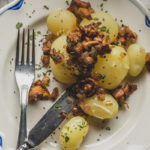 A plate of boiled summer potatoes and sautéed onions and chanterelles.
