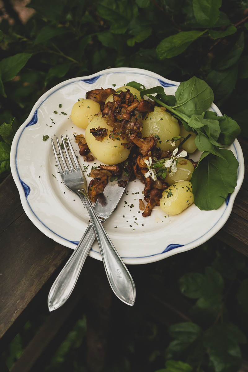 Chanterelles and Summer Potatoes on a plate with wild arugula and spices.